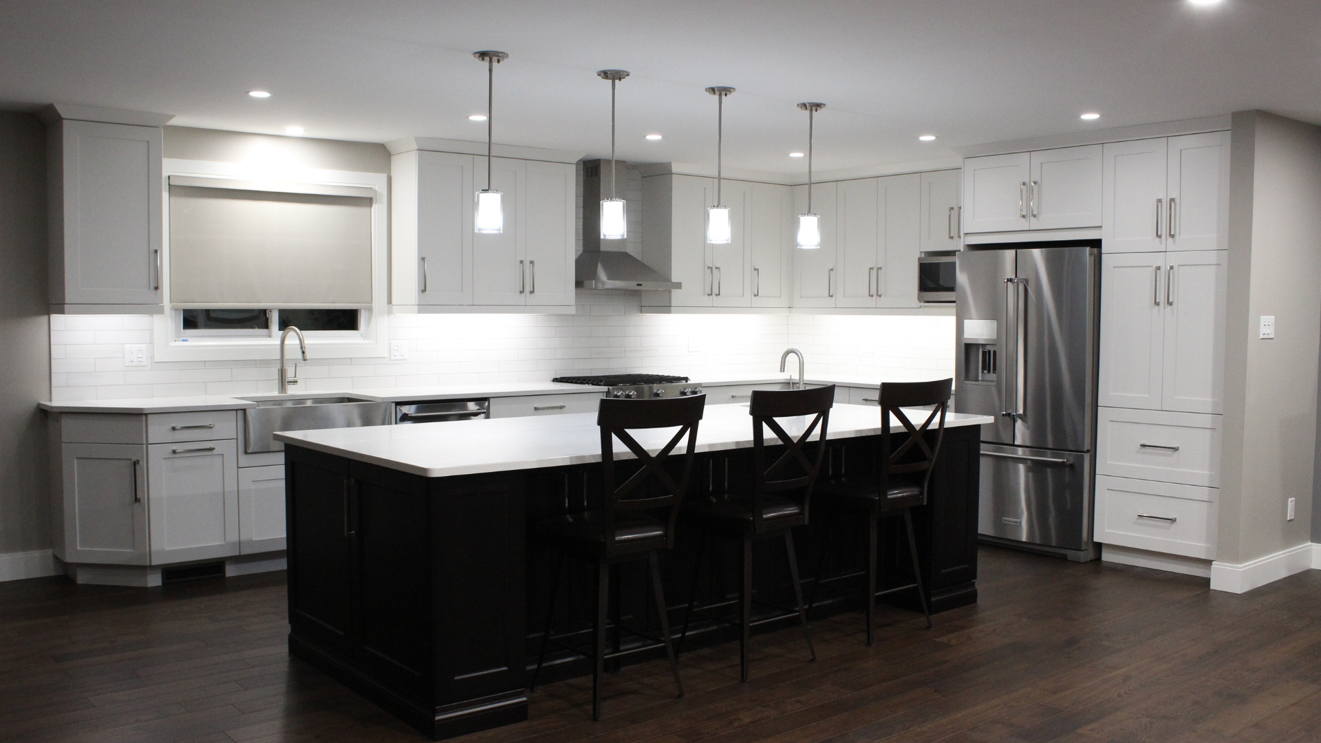 white cabinets and dark island cabinets in new kitchen design with stone countertops